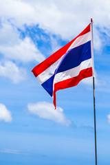 flag of Thailand flagstaff waving against blue sky with white clouds close-up sunny day