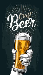 Male hand holding a glass. Craft Beer lettering. Engraving