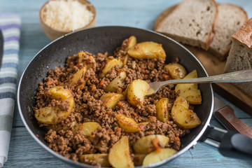 Savory mince and potato wedges in a frying pan - rustic dish