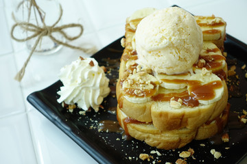 Honey banana toast with vanilla ice cream served on white table