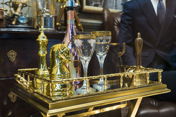 Obraz premium Luxurious golden champagne tray ready to serve with man in blue suit