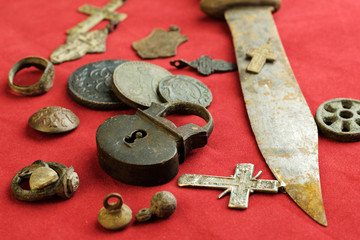 rusty knife and castle hinged ancient Russian objects of the 18th century on a red cloth