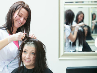 Woman getting hair colored in beauty salon