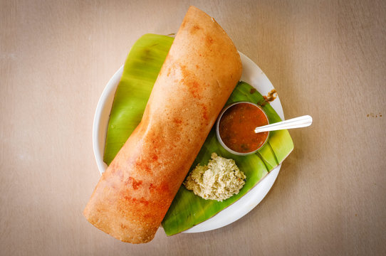 Traditional Southern Indian rice Dosa on banana leaf.