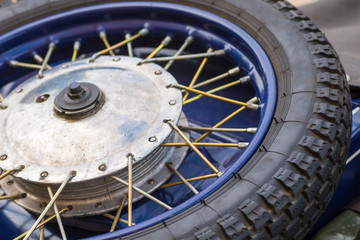 Fototapeta na wymiar Tire motorcycle wheel with metal spokes vintage car close-up