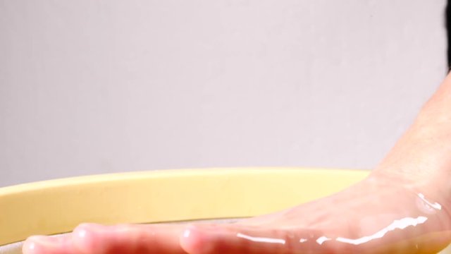 Close up slow motion shot of unrecognizable woman putting hand into paraffin bath taking care of hands skin