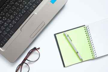 Laptop computer, eyewear and notebook with pen, Workplace on white background