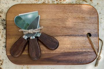 small cheese slicers on wooden chopping block