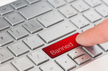 A finger press red banned button on laptop keyboard