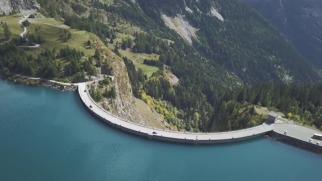 Mountain dam aerial shot - Hydro electric power station. Cinematic drone shot of a dam in the Swiss alps
