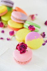 Delicate Fresh Colorful French Macaroons In Pastel Colors With Flowers Roses On A Light Textile Background