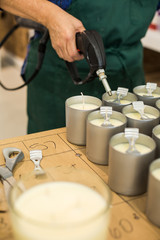 Closeup of Hands Heating Candle Wicks of Homemade Candles