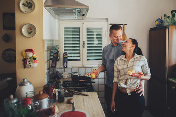 Romantic couple in love spending time together in kitchen