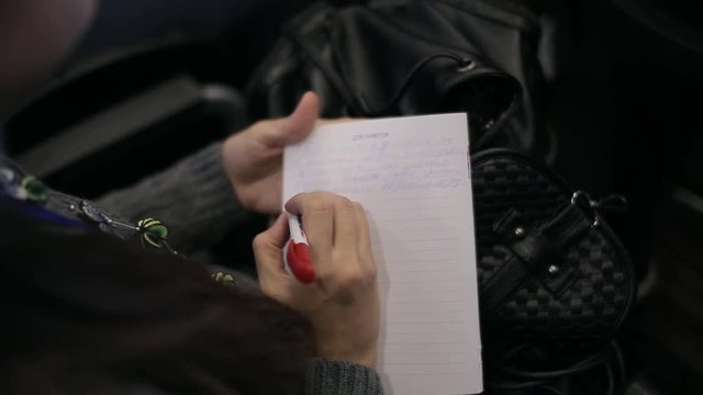Women writes in a notebook at a conference