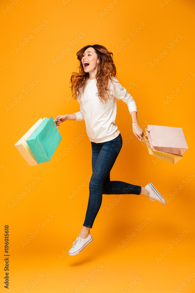 Poster full length image of cheerful brunette woman in sweater running