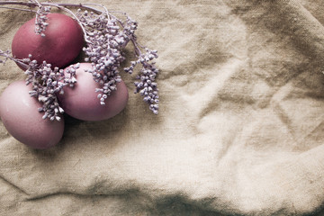 Obraz na płótnie Canvas Painted Easter eggs on sackcloth decorated with lavender, rustic festive composition