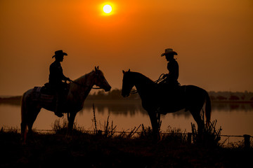 Silhouette Cowboys and friends meet each other on horseback