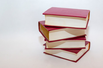 Stack of small books in hard cover on a white background
