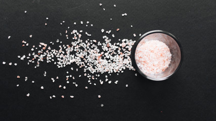 Glass with flavored salt on black background
