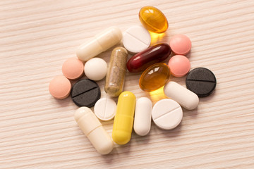 The pills are scattered on the table . On light background
