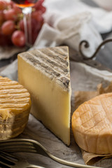 Tasting of oldest french AOC soft pudgent yellow cheese Livarot,  Munster and semifirm Tomme french cheeses