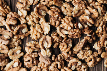 Pile of shelled walnuts on wooden background, healthy eating concept