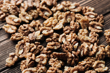 Pile of shelled walnuts on wooden background, healthy eating concept