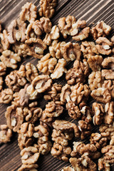 Pile of shelled walnuts on wooden background, healthy eating concept