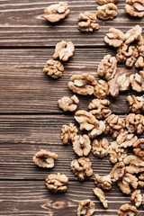 Pile of shelled walnuts on wooden background, healthy eating concept