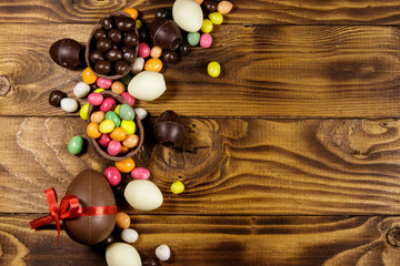Easter composition with chocolate eggs on wooden background