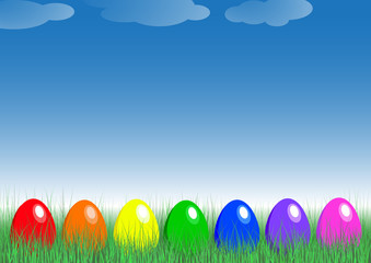 Rainbow eggs in the grass. Seven eggs in rainbow colors lie in the grass in the meadow. 3 small clouds are in the blue sky. In the background is gradient from sky blue to white and green.