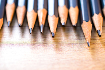 Obraz premium black pencils isolated on wood surface background.Close up.