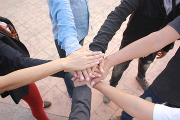 Meeting teamwork concept,Friendship,Group people with stack of hands showing unity on concrete floor background