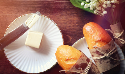 Fresh rolls for breakfast. Bun with butter to a cup of coffee in