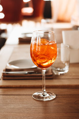 Delicious cocktail with ice cubes on wooden table