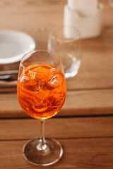 Delicious cocktail with ice cubes on wooden table