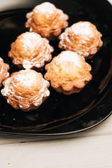 Delicious sweet cupcakes on black plate, delicious homemade dessert