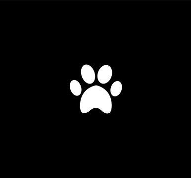 White animal paw print icon isolated on black  background.