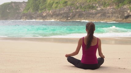Fototapeta na wymiar Woman meditates in yoga asana Padmasana