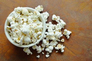 salty popcorn in cup on wooden table