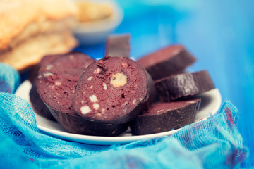 portuguese blood sausage on white plate on blue background