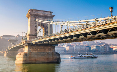 Obraz premium Piękny widok na Most Łańcuchowy na Dunaju z łodzią w Budapeszcie na Węgrzech
