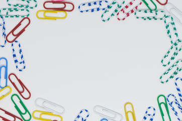 Colorful paperclip flat lay with copy space in the center for as the message frame