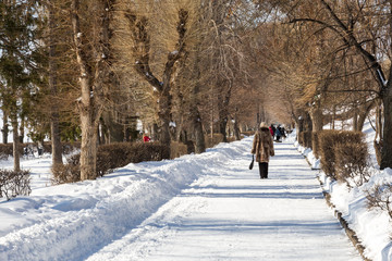 An elderly woman walks in the Park. Winter day.