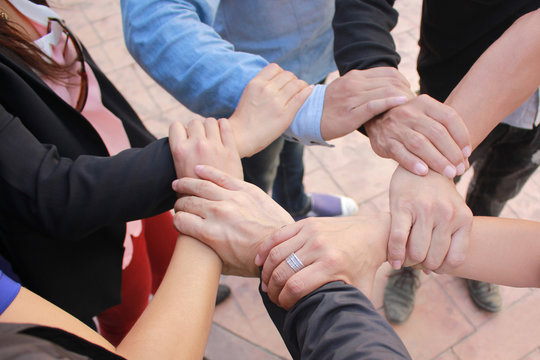 Meeting teamwork concept,Friendship,Group people with stack of hands showing unity on concrete floor background