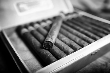 Retro styled photo of large box of Cuban cigars on a wooden tabl