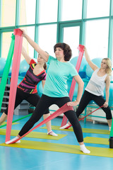 Women doing gym exercises using latex fitness bands