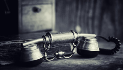 Old telephone and retro book on the desk. The phone of the past 