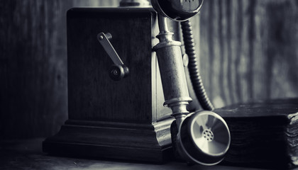 Old telephone and retro book on the desk. The phone of the past 