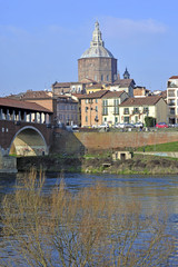 Italy - Pavia - The Covered Bridge (also called Ponte Vecchio) on the ticino with the Cathedral of the city in the background